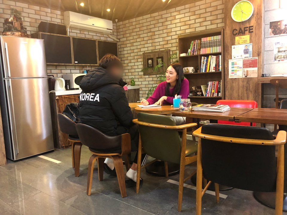 수강생과 마주 앉아 웃으며 상담하는 선생님